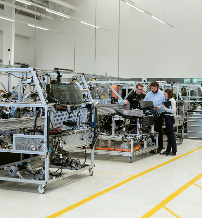 Team reviewing work on a clean manufacturing floor